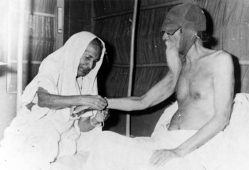 Jankidevi Bajaj tying a rakhi to Vinoba Bhave during a Rakshabandhan Samaroh at Mahila Ashram (circa 1951).
